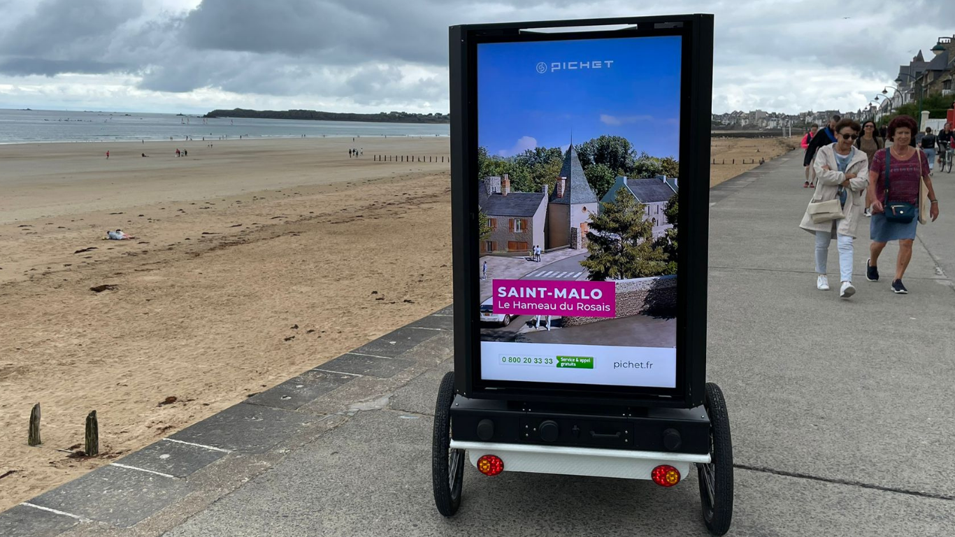Vélo publicitaire Digibike Pichet Immobilier en circulation sur la plage Vélo publicitaire Digibike Pichet Immobilier en circulation sur la plage