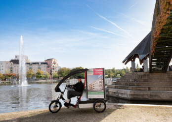 Vélo publicitaire Digibike Pichet Immobilier en circulation sur le marché de Saint-Servan-sur-Mer